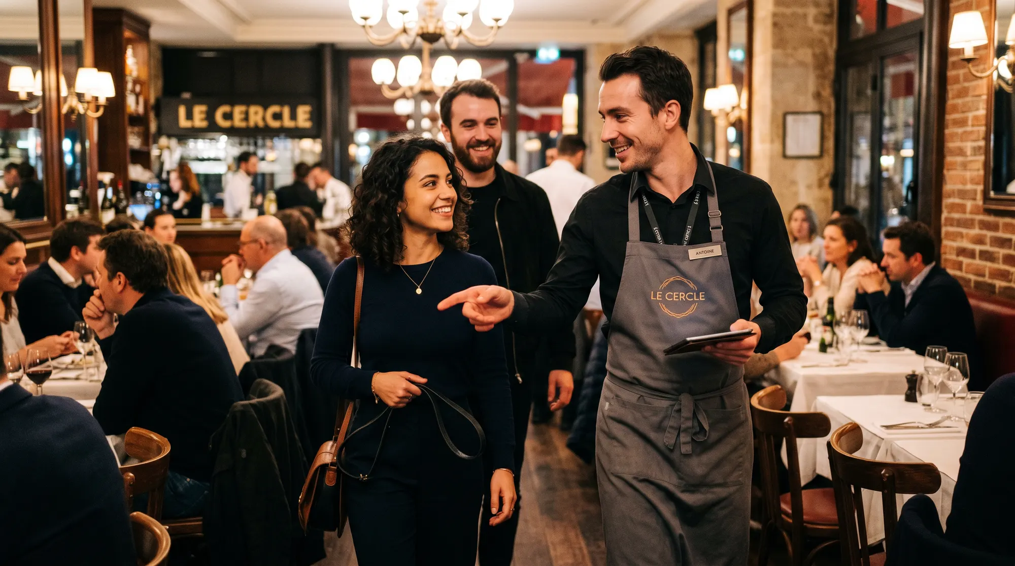 Serveur accueillant des clients dans une salle de restaurant bondée en plein service